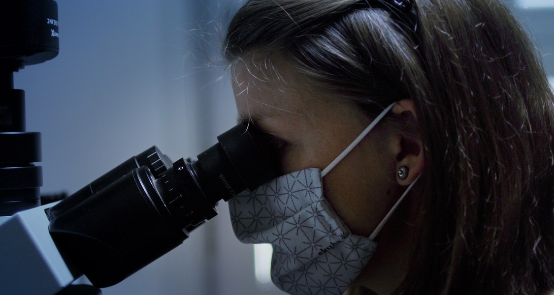 Close-up of Nadine Leisgang looking through a microscope