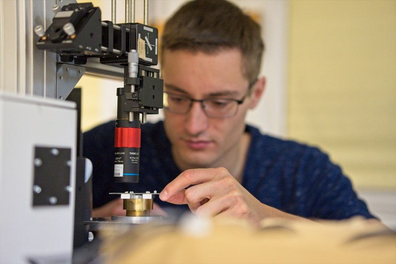 Foto of scientist adjusting the photoluminescence spectroscopy setup