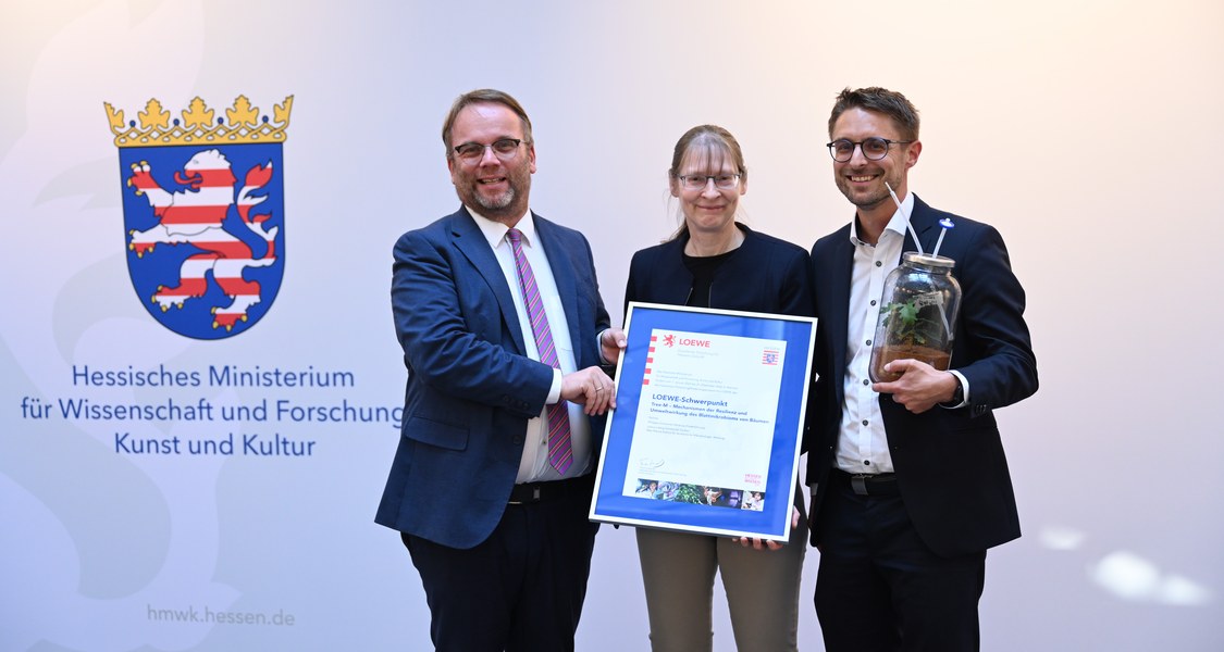 Der Hessische Wissenschaftsminister Gremmels übergibt die Förderungs-Urkunde an Frau Prof. Dr. Anke Becker und Herrn Dr. Rebelein von der TREE-M Forschungsgruppe der Universität Marburg
