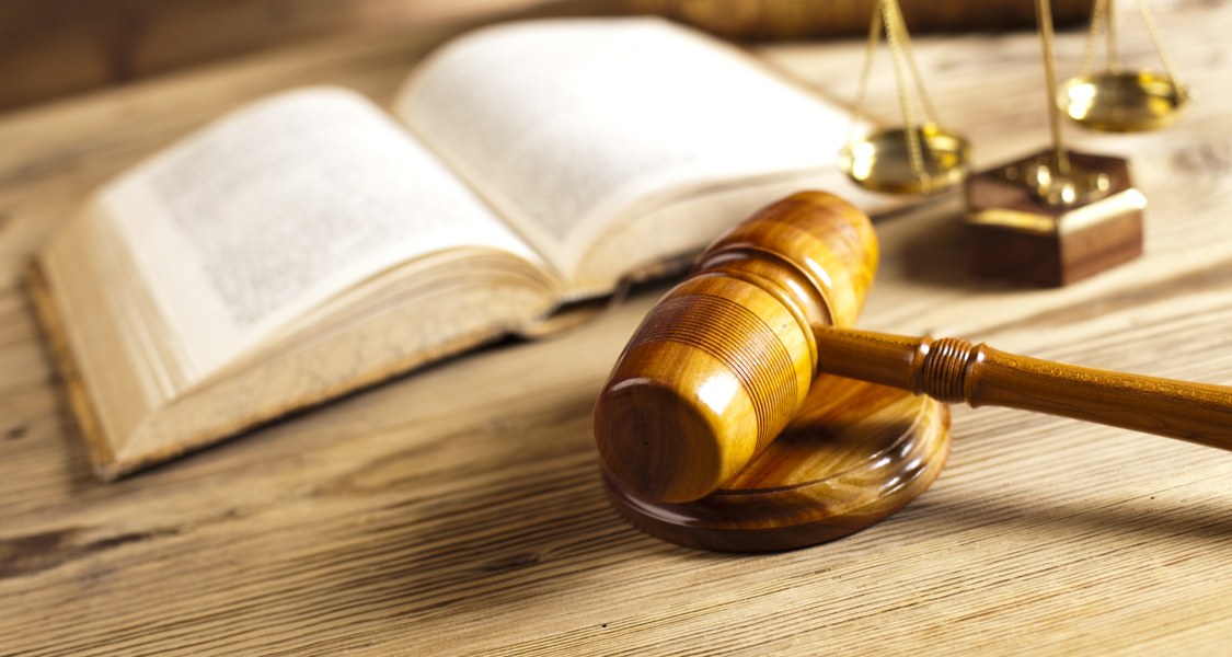 Book, scales and judge's hammer symbolize utensils of everyday court life.