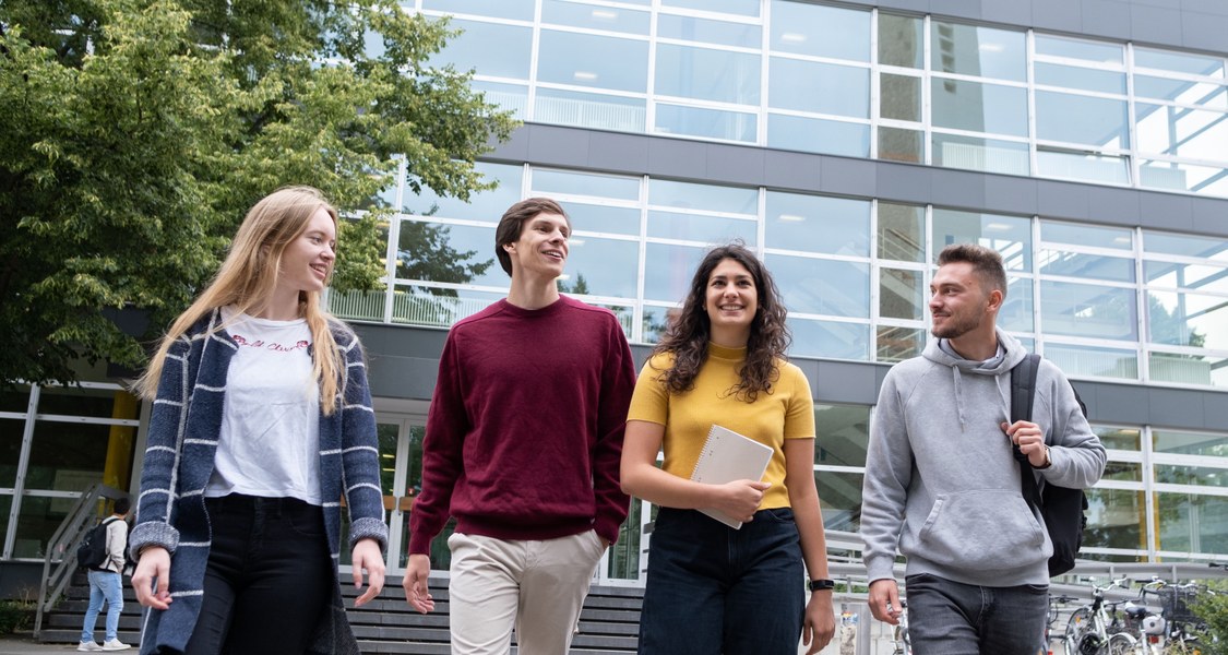 Four students in front of the lecture hall