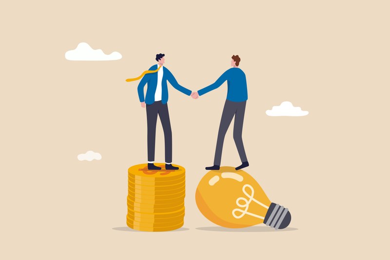 Two cartoon characters can be seen shaking hands. One cartoon character is standing on a pile of coins, the other on a glowing light bulb.