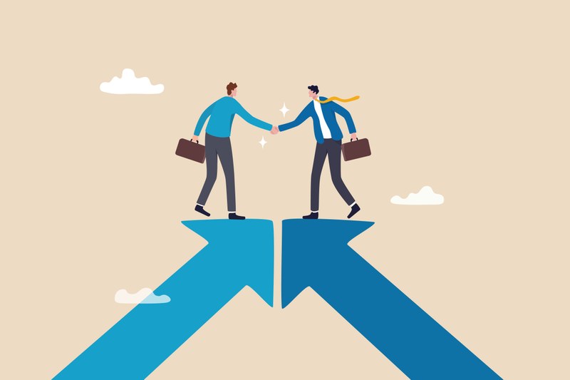 Two cartoon characters can be seen shaking hands. The cartoon characters are each standing on the tip of an arrow. Both arrows point diagonally upwards and meet at the tip.