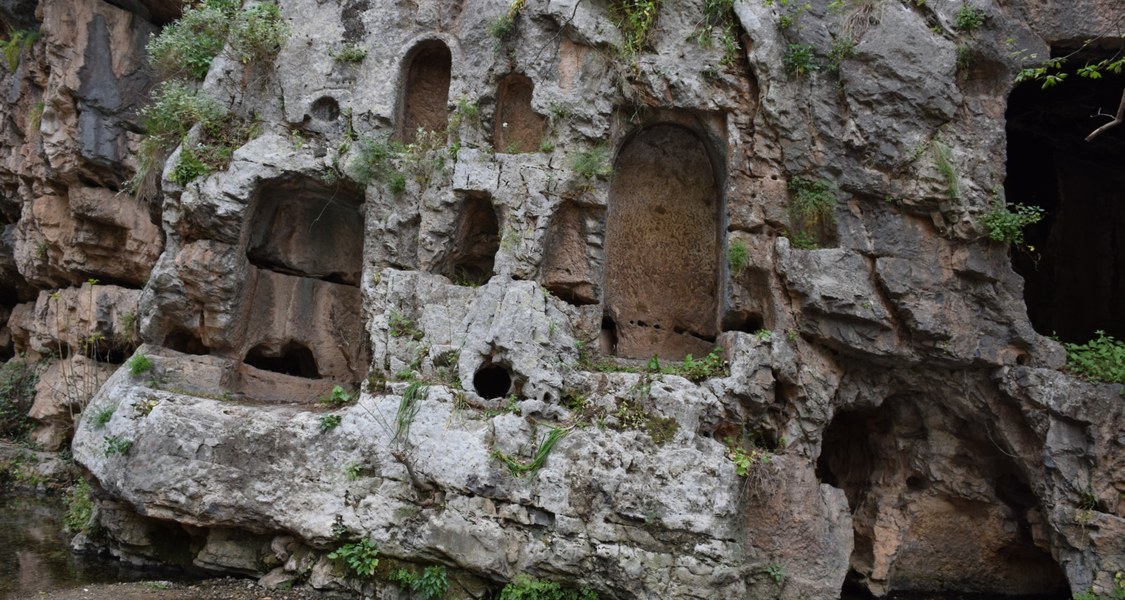 A cliff face with different sized niches cut into it