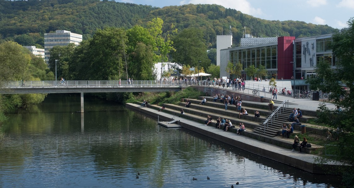 The student union and humanities building in the summer sunshine, flanked by the Lahn and the Lahnberge.