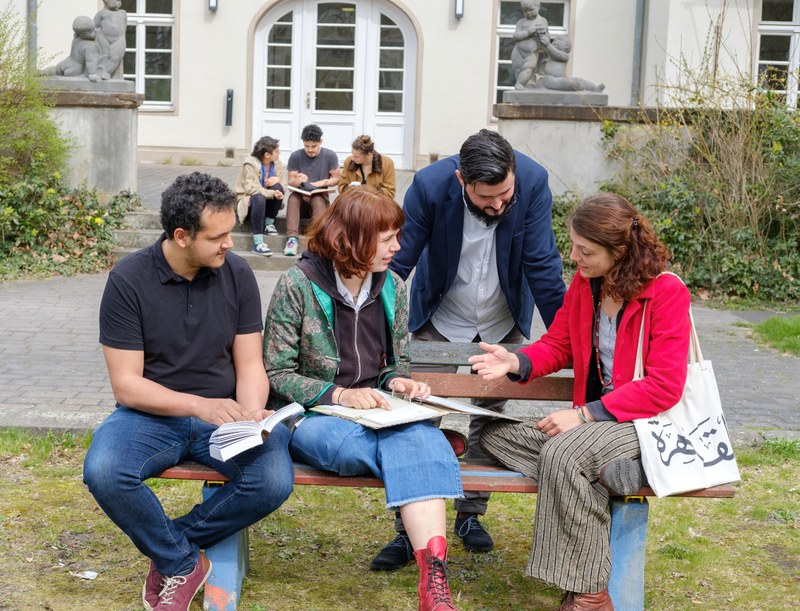 Group of young people, in the background the building of the CNMS