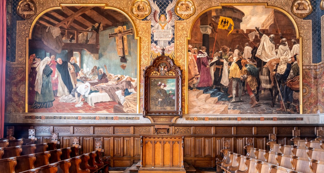 Old Aula: richly decorated historical hall with paintings, wooden pews and lectern